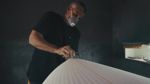 Surf Factory - Ein erwachsener männlicher Shaper stellt das Surfbrett in der Fabrik her