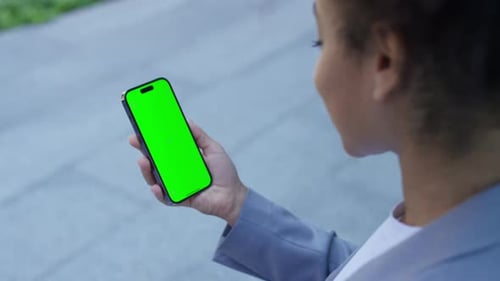 Woman Holding Smartphone with Green Screen Display