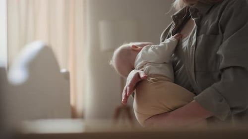 Young Mother Holding Close Sleeping Baby Creating Nurting Connection