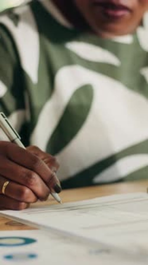 Woman Writing on Paper at Office Desk