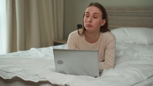 Frustrated Woman Using Laptop on Bed