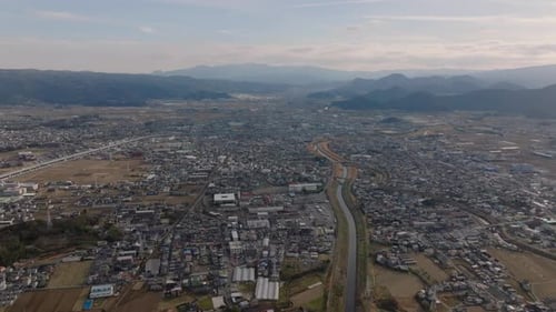 Aerial Panoramic View of Town in Wide Valley Surrounded By Mountains River Flowing Through City