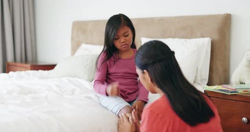 Girl Receives Bandage from Mother on Bed