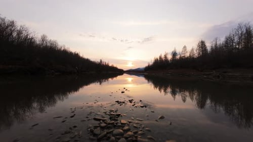 A breathtaking view unfolds as the sun dips below the horizon, casting golden reflections on a calm