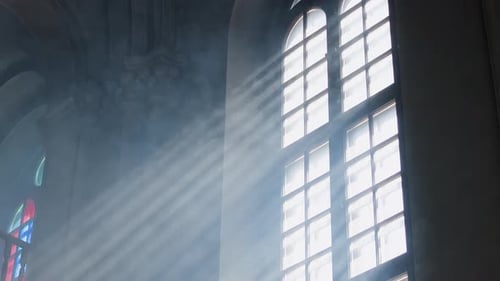 Sonnenstrahlen strömen durch ein großes Bogenfenster in der Kathedrale