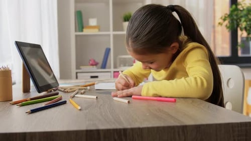 Little Girl Drawing with Colored Pencils at Home