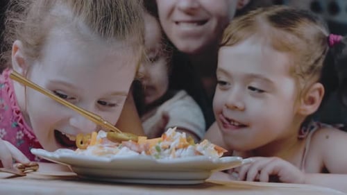 La mère et les filles dégustent la salade de pommes de terre au piment jalapeno et au bacon dans le style rétro