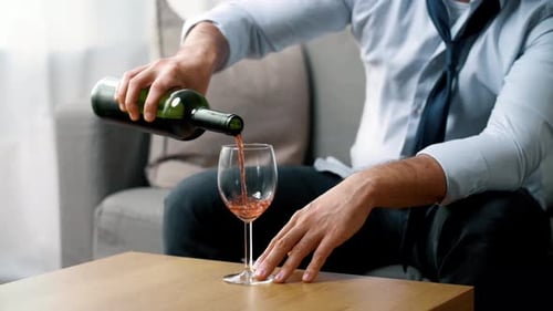 Man in Unbuttoned Shirt Pours Wine in Living Room