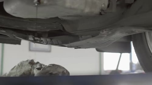 Ein Mechaniker verwendet alte Lappen, um Teile eines Autos zu reinigen und Wartungsarbeiten durchzuführen