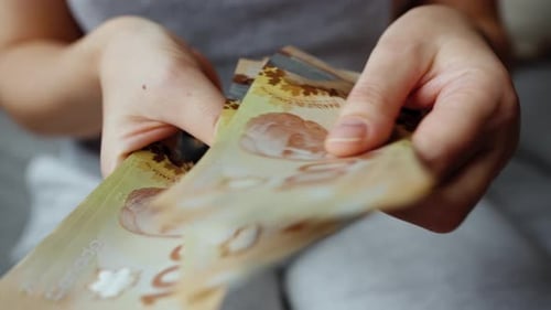 Female Hands Counting Canadian Dollar Bills Closeup