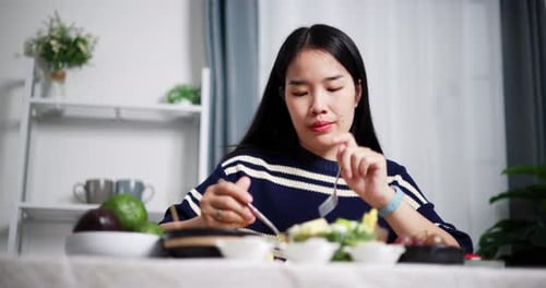 Woman Eats Healthy Salad at Home at Table