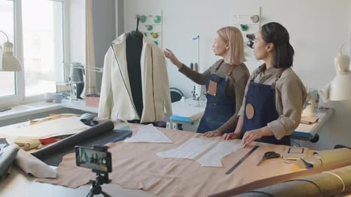 Dos diseñadoras de moda grabando un tutorial de costura para un curso en línea
