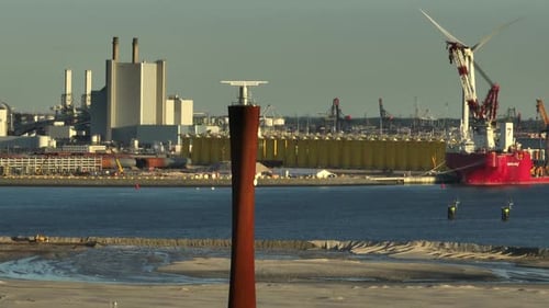 Aerial orbit around maritime radar tower and Port of Rotterdam, Netherlands at golden hour