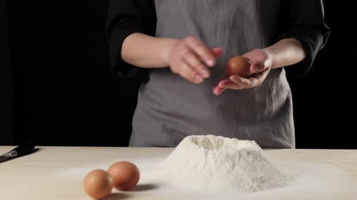 Egg Cracking into Flour for Baking Dough