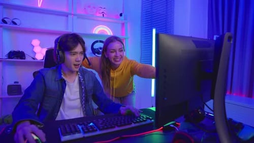 Excited Couple Gaming Together at Home at Night