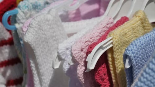 Colorful Knitted Children's Clothes on Hangers