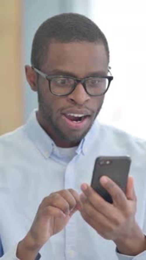 Excited Man Celebrates While Using Mobile Phone