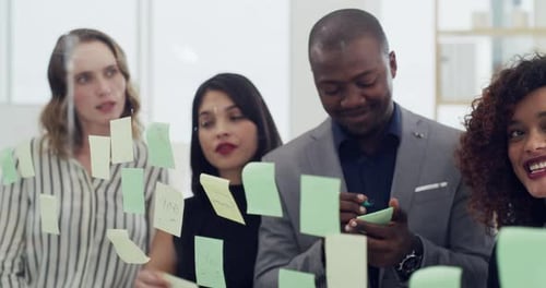 4k video footage of a group of businesspeople brainstorming with notes on a glass wall in an office