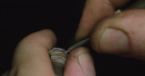 Close up of the hands of a goldsmith while he is working on a diamond ring. Concept: Style, fashio