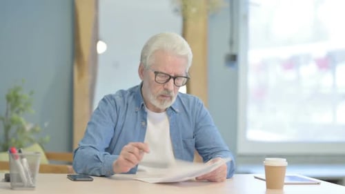 Old Man Reading Documents in Office, Paperwork