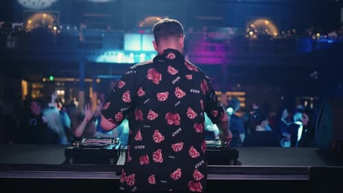 Leute, die sich auf einer Elektronisch Tanzparty ausruhen, Rückansicht eines DJ-Mannes, der Techno-Musik spielt, und Tänzer