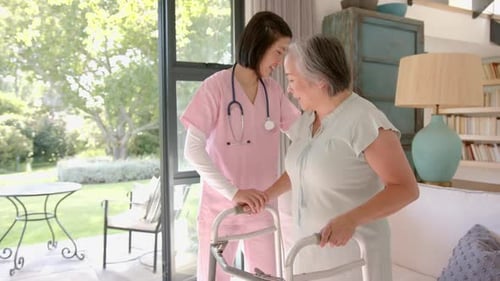Helping senior asian woman with walker, nurse providing physical therapy at home