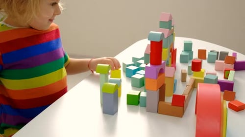 Child Playing with Colorful Wooden Building Blocks at Table