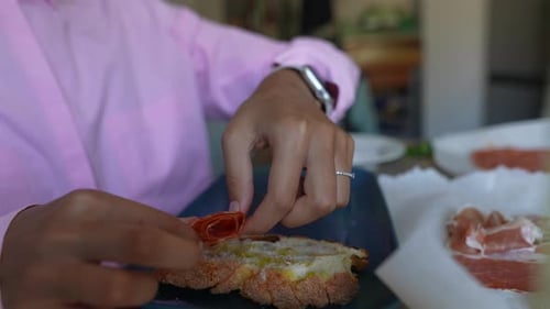 Woman Arranges Charcuterie on Bread for Appetizer