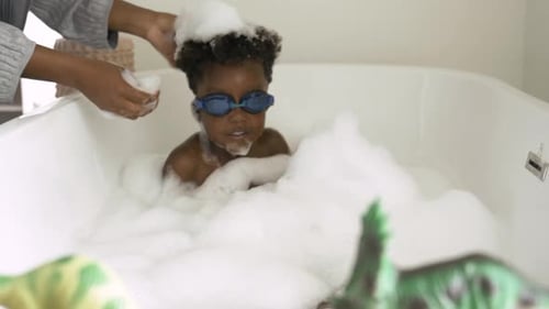 Young Boys Play in Bubbles in Bathtub with Parent
