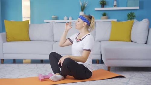 Woman Drinking Water After Exercise in Home