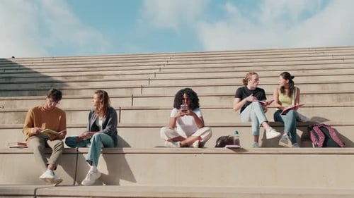Students Reading and Conversing on Outdoor Steps