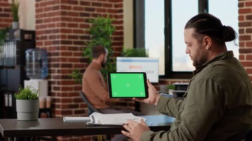 Man Holding Tablet with Green Screen in Office