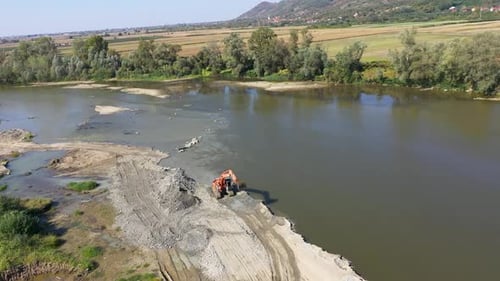 Aerial view of illegal exploitation of river sand and gravel with excavator on river bank by drone