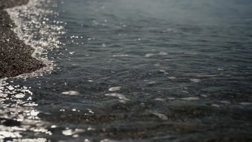 Ruhiger Meerblick mit Wellen, die sanft den Sandstrand umspülen und eine friedliche Szene schaffen