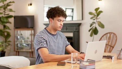 Man Using Laptop at Table in Bright Home