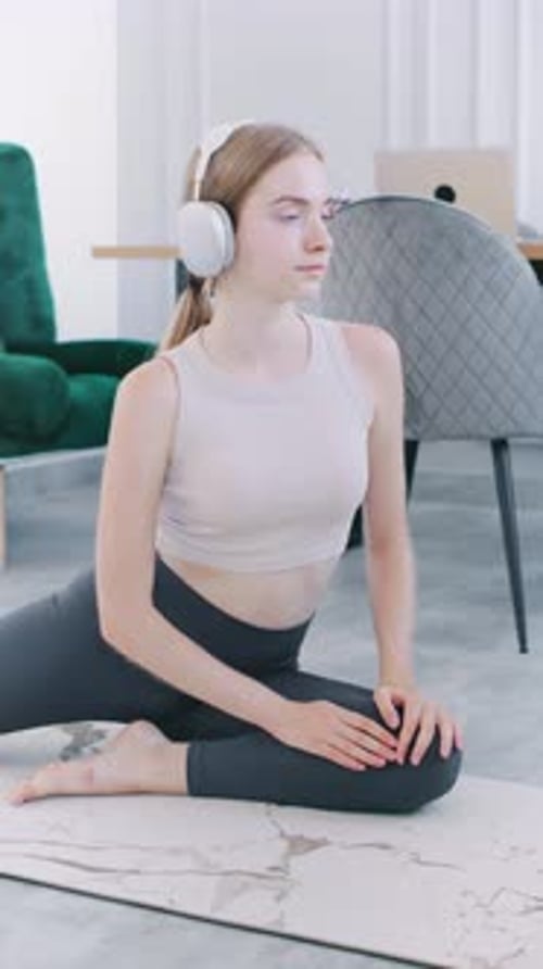 Young Woman Stretching on Yoga Mat Indoors