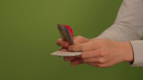 An UpClose Image Featuring Hands Firmly Gripping a Payment Card Set Against a Green Background