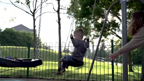 Child Swinging Happily on Playground Swing Set