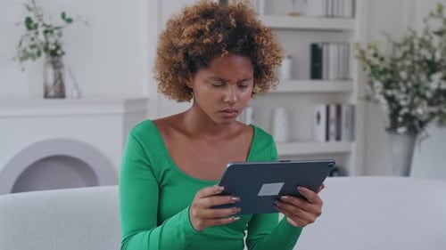 Adult Using Tablet on Couch Indoors