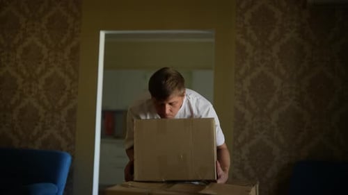 Man Lifting Cardboard Box and Moving