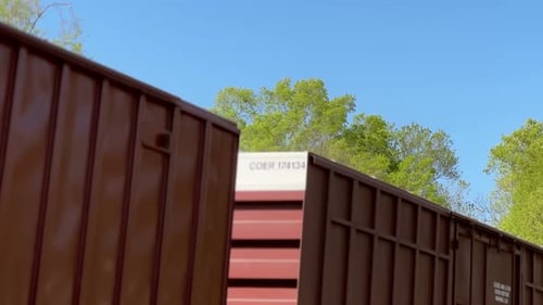 O trem de carga passa com contêineres e petroleiros sob um céu azul, 30 fps