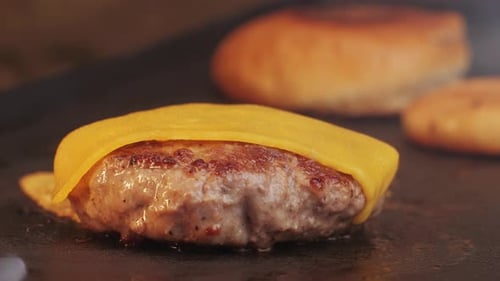 Cooking American Fat Smash Burger with Cheese Slice on Top on Grill Closeup Beef or Pork Cutlet