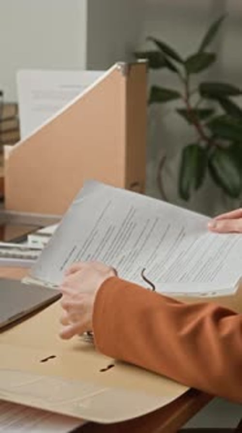 Office Worker Filing Paper Documents in Folder