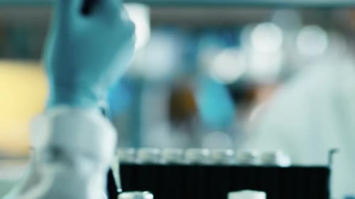 Close-up footage of a scientist using a micro pipette in a laboratory.