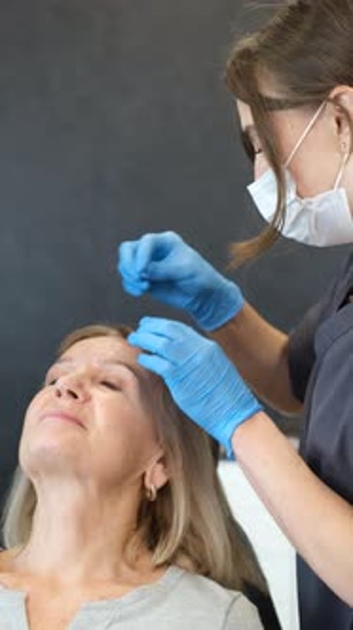 Vertical Video of a Cosmetologist Making Injections in a Cosmetic Clinic A Doctor Injects Vertical