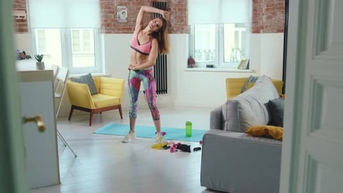 Sportliche brünette Frau aus nächster Nähe macht Übungen auf der Matte im hellen Raum, Fitnesstraining zu Hause
