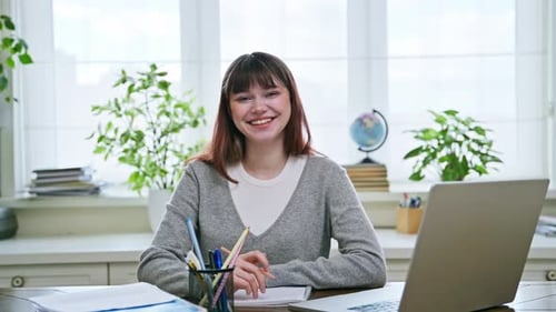 Young Happy Female College Student Studying at Home Using Laptop Smiling Looking at Camera