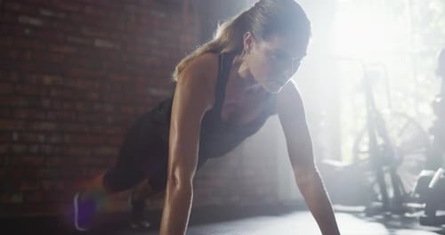 A young woman doing push ups at the gym