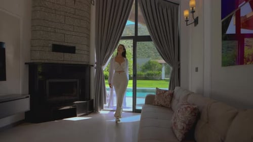 Woman in White Outfit Enters Living Room
