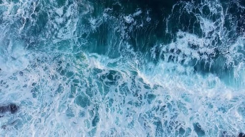 Aerial View Capturing the Dynamic Ocean Waves and Surfing Foam in Irresistible Detail